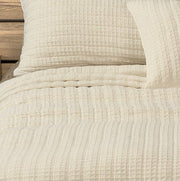 Close-up of the Spirit cream cotton quilt and pillow sham showing the waffle texture.